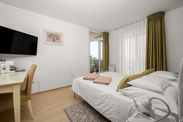 Soba Fuma — krevet, radni stol i izlaz na balkon